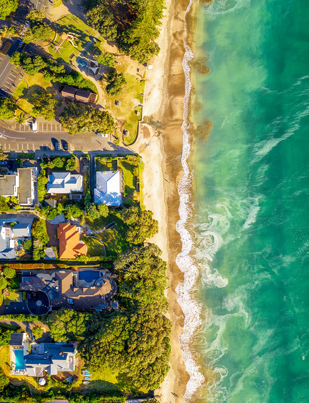 A view of beachside homes in the Takapuna district of Auckland, New Zealand from directly above the beach.